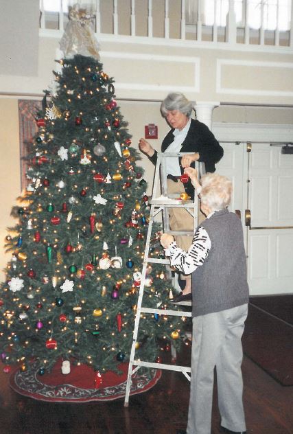 Decorating The Tree The West End Home For Ladies, 2818 Vanderbilt Place, December 2002 (On ladder) Gayle Smith, Auxiliary member, Mrs. Lula Belle Parker Austin (1908-2007) 